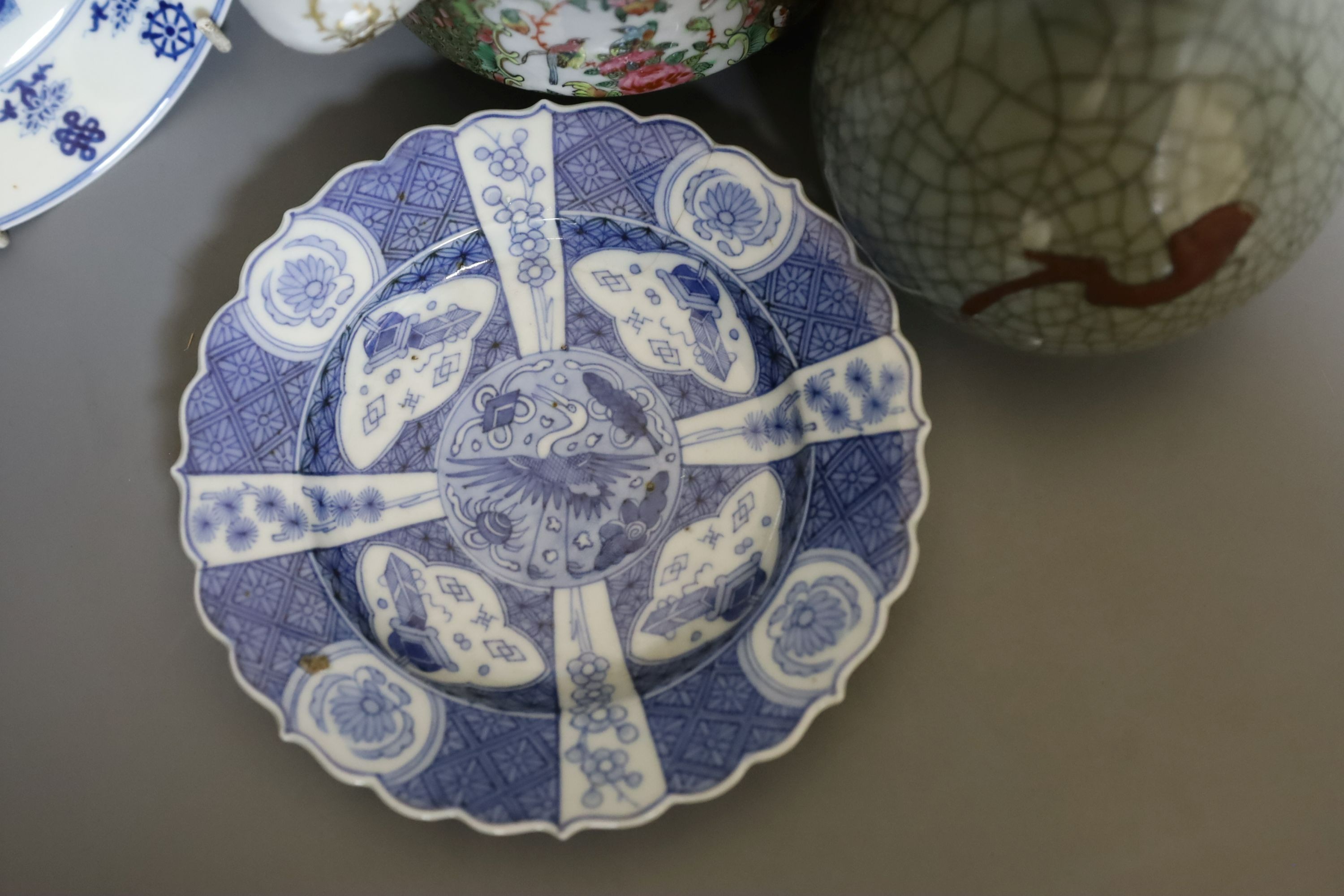 Three Chinese plates including a 19th century Chinese Imari dish, 23cm - repaired, a Chinese famille rose crackleglaze vase, 29cm, together with a famille rose teapot and a crackleglaze celadon ground bottle vase. Talles